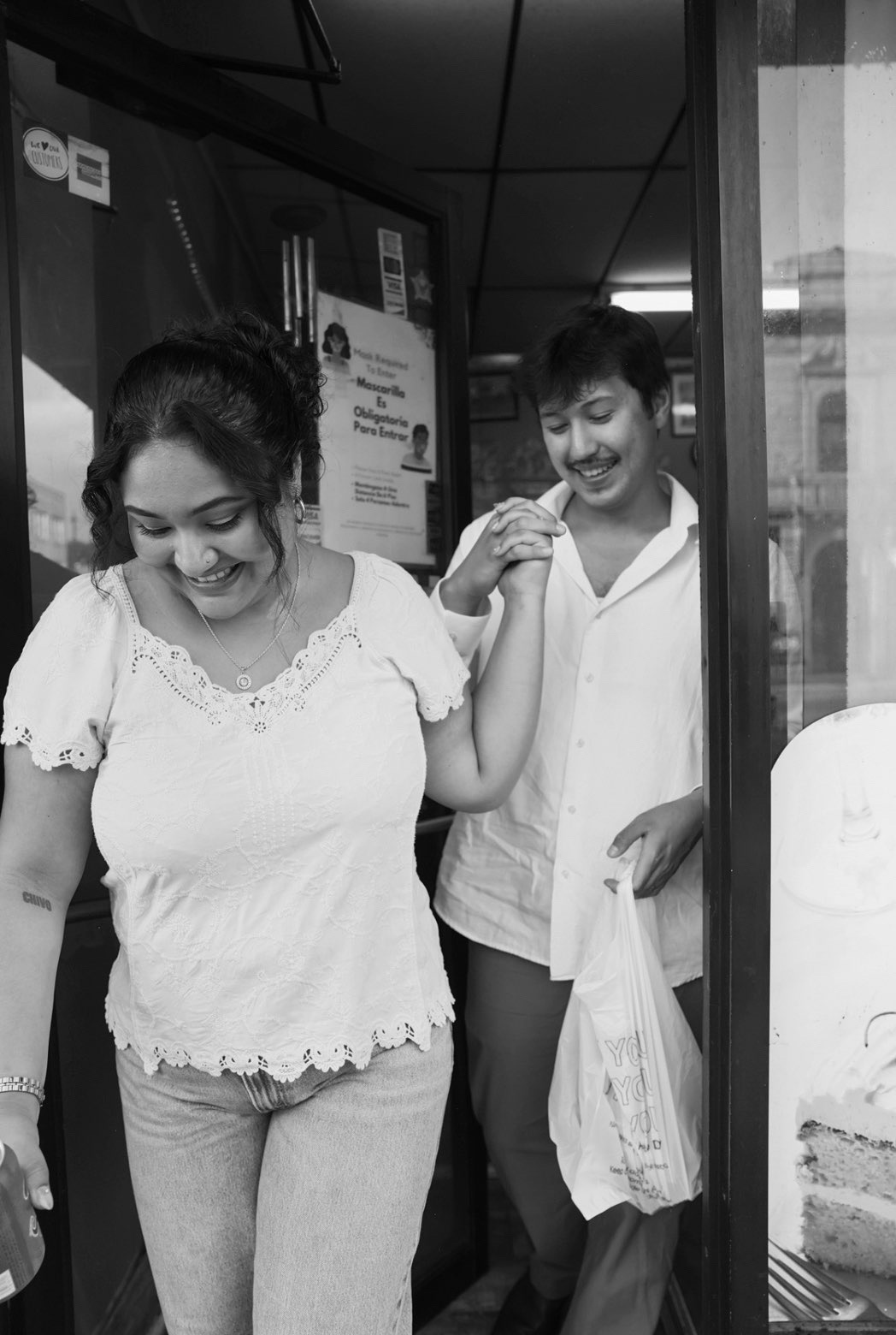 Ethan and Elli leaving a neighborhood bakery, hand in hand